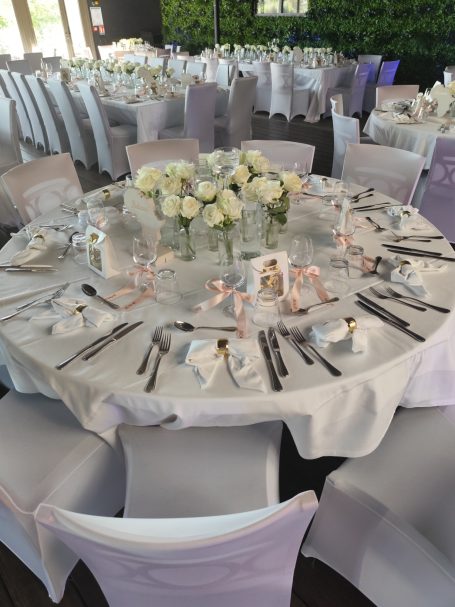 Table élégamment dressée avec des roses blanches et de la décoration raffinée.