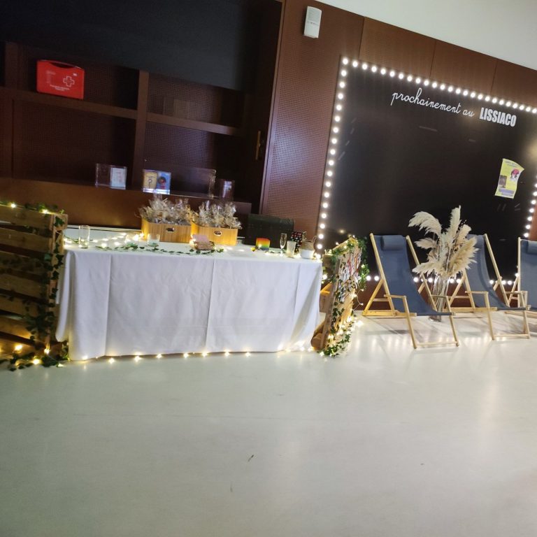 Décor de fête avec une table décorée et des chaises longues agencées.