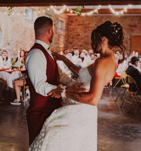 Un couple danse lors de leur mariage dans une ambiance festive.